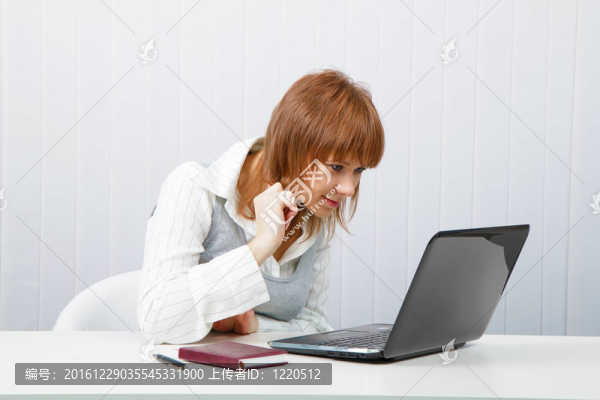 辦公室里帶著筆記本電腦的迷人的微笑女孩