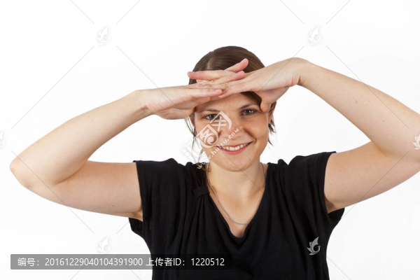 幸福的女人微笑著看著雙手作為防曬