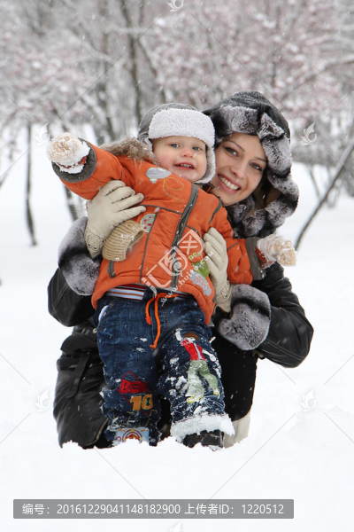年輕的媽媽和她的兒子在雪中