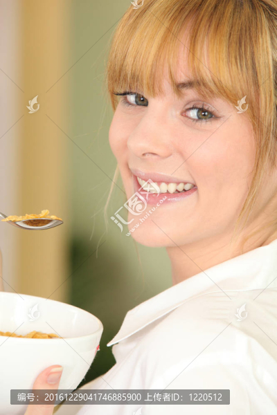 年輕的女人吃一碗麥片