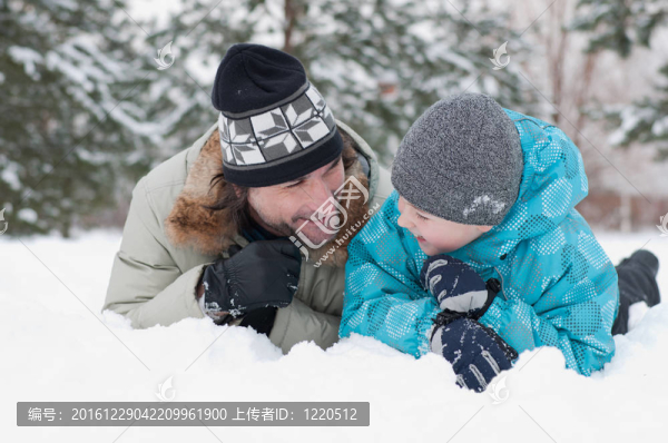 爸爸和兒子在公園里的雪地里休息