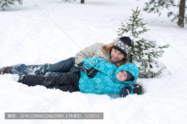 爸爸和兒子在公園里的雪地里休息