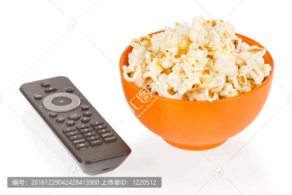 橙汁里的爆米花和白色背景的遙控器