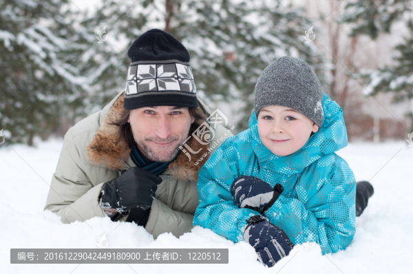 爸爸和兒子在公園里的雪地里休息