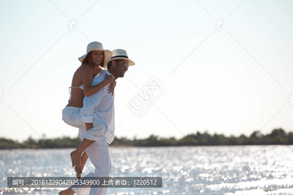幸福的夫婦在海邊騎馬