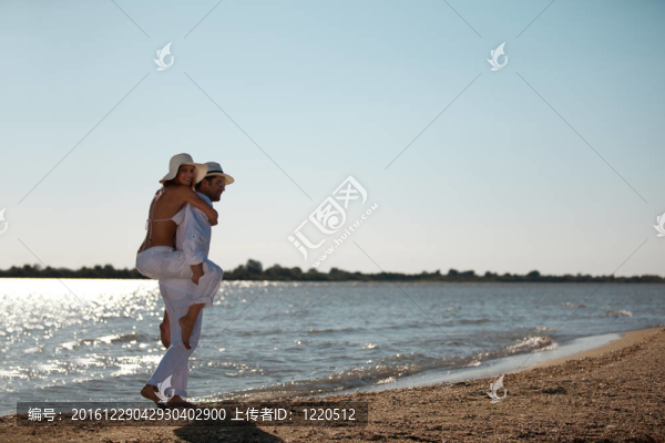 幸福的夫婦在海邊騎馬