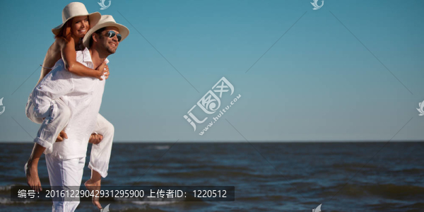 幸福的夫婦在海邊騎馬