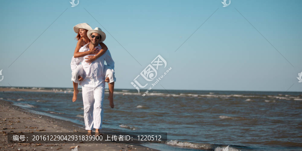 幸福的夫婦在海邊騎馬