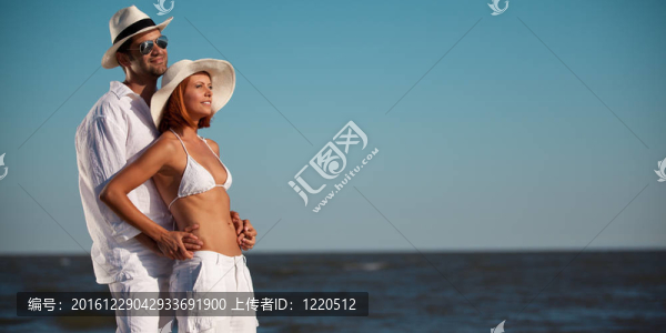 快樂的年輕夫婦互相擁抱海邊