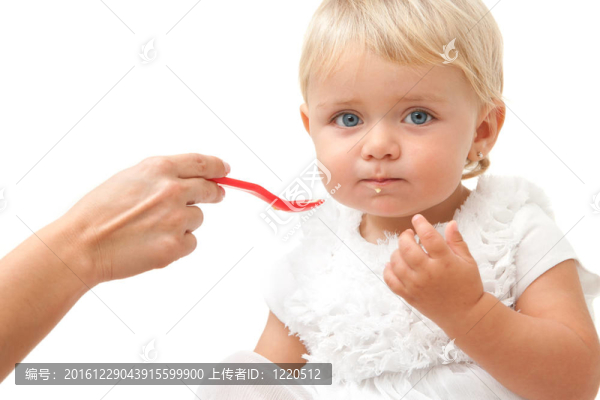 藍眼睛嬰兒的手和湯匙肖像