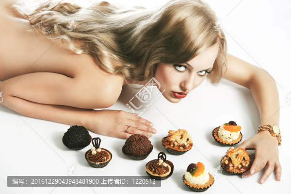 金發(fā)性感女孩吃糕點(diǎn)；她看著鏡頭