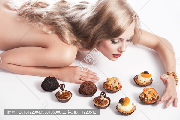 金發(fā)性感女孩吃糕點(diǎn)；她看起來糕點(diǎn)