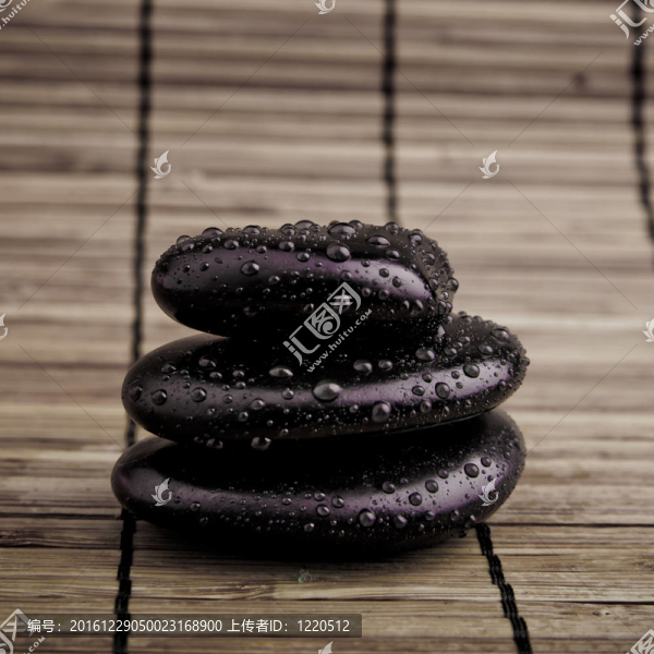 溫泉的石頭。黑色閃亮的禪石與水滴黑色背景