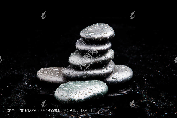 溫泉的石頭。黑色閃亮的禪石與水滴黑色背景
