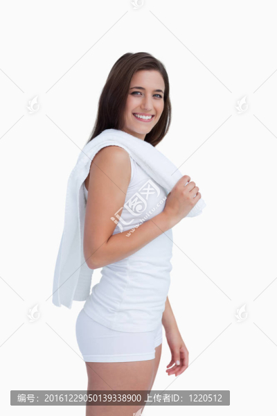 微笑的女青年拿著毛巾在她的肩上