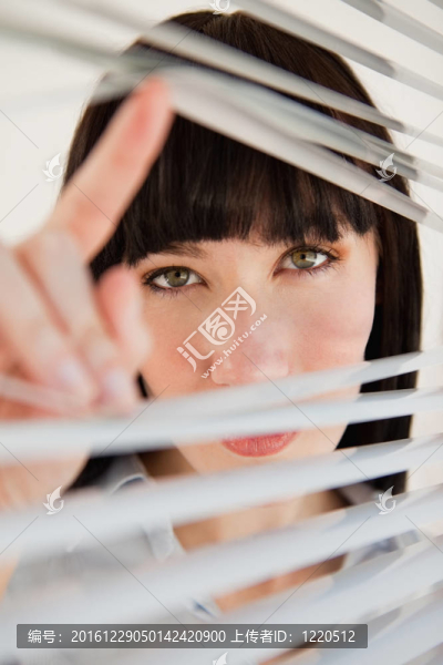 一個(gè)女人穿過百葉窗進(jìn)入相機(jī)