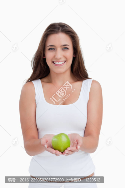 微笑的女人拿著蘋果看著相機