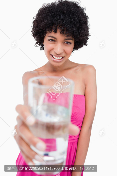十幾歲的女孩拿著一杯水在她面前微笑著