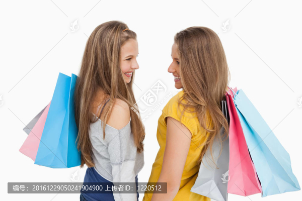 兩個購物袋年輕女子的后視圖