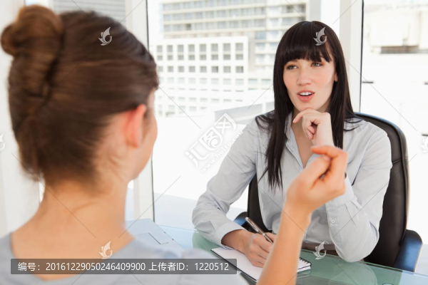 一個(gè)商業(yè)婦女傾聽辦公室里的另一個(gè)女人