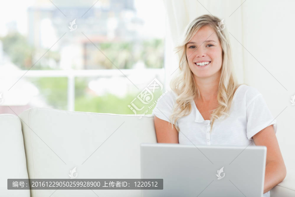 一個面帶微笑的女人手里拿著筆記本，看著