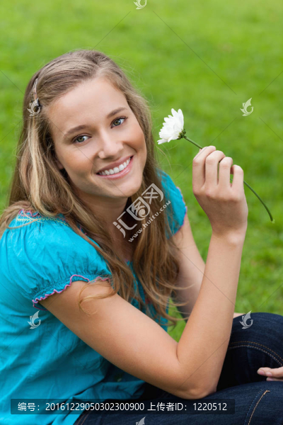 年輕女子微笑著抱著花坐下