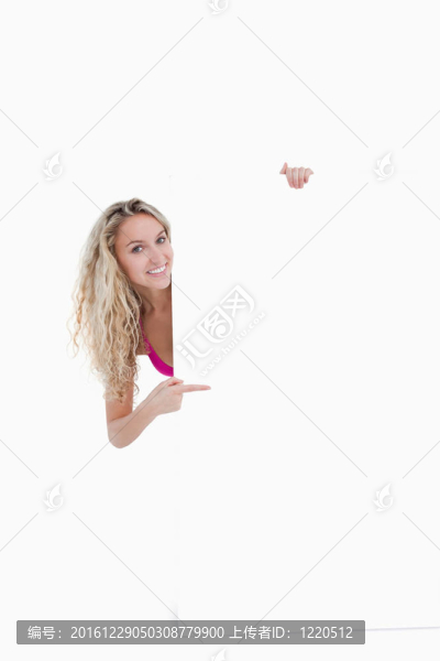 十幾歲的女孩指著手指指著一張空白海報