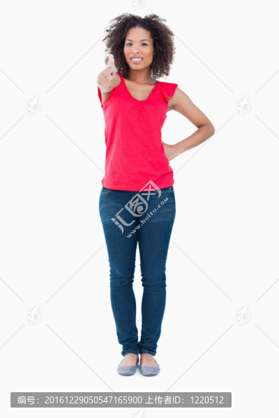 微笑的年輕的黑發(fā)女人把她的大拇指