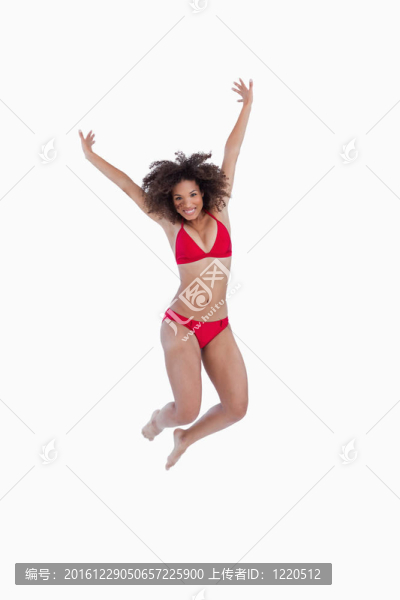 快樂(lè)的黑發(fā)女人跳而舉起手臂
