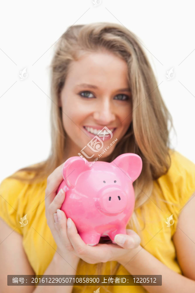 金發(fā)女郎抱著小豬存錢罐