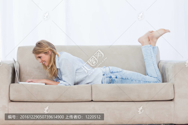 一個面帶微笑的女人躺在沙發(fā)上盯著她