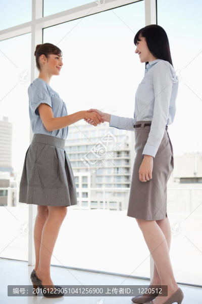 兩個(gè)女人握手時(shí)微笑