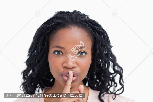 一個(gè)年輕的女人用她的手指到她的嘴唇
