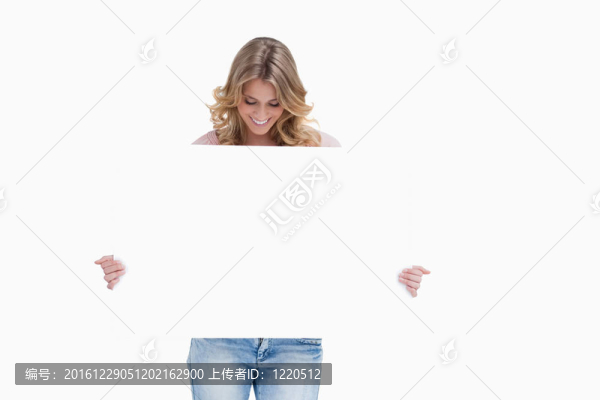 一个金发女人低头看着她手里拿着白色的海报