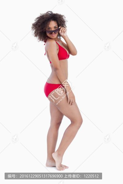微笑的女人在海灘看著她的太陽鏡