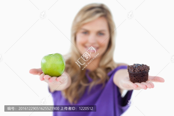 一個(gè)綠色的蘋(píng)果和一個(gè)松餅被一年輕女子舉行