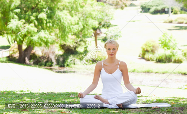 在公園里坐著瑜伽姿勢的女人