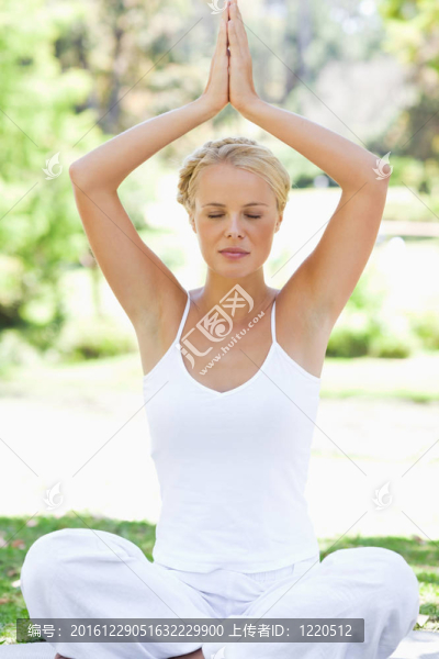 輕松的女人在草地上的瑜伽姿勢