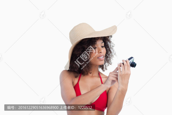 迷人的女人看著她的數(shù)碼相機