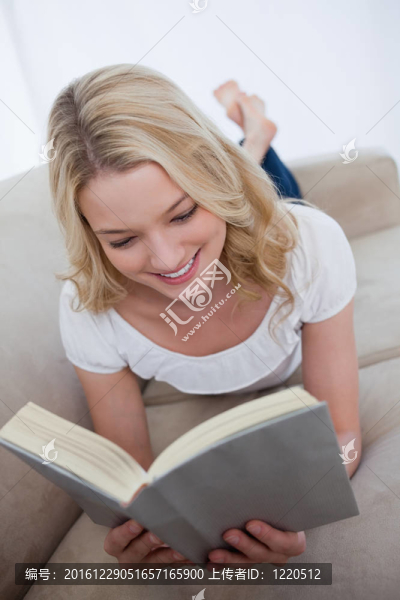 躺在沙發(fā)上的女人正在看書