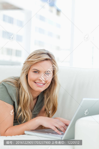 女人微笑著看著筆記本電腦