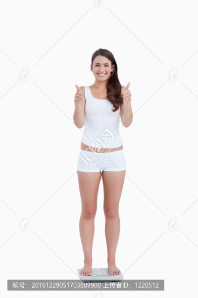 微笑女子豎起大拇指，站在稱重