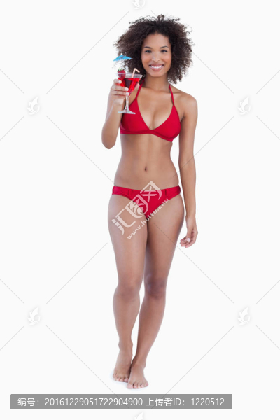 漂亮的黑發(fā)女人抱著一個(gè)雞尾酒而微笑