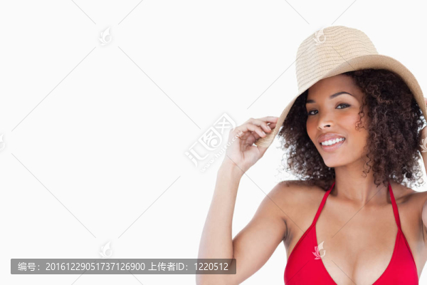 面帶微笑的女人拿著草帽看著相機(jī)