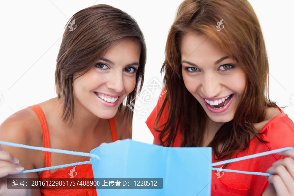 兩個(gè)十幾歲的女孩拿著購(gòu)物袋微笑著