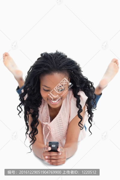 前視圖的女人躺在地板上發(fā)短信她莫
