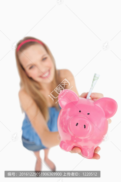 一個(gè)年輕的女人把錢放在一個(gè)撲滿魚眼視圖