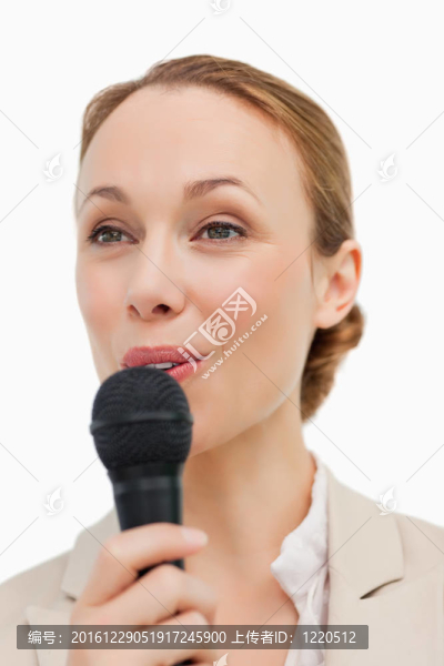 穿西裝的女人用麥克風說話