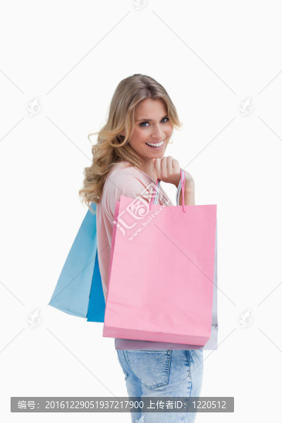 一個(gè)拿著購(gòu)物袋的女人對(duì)著照相機(jī)微笑