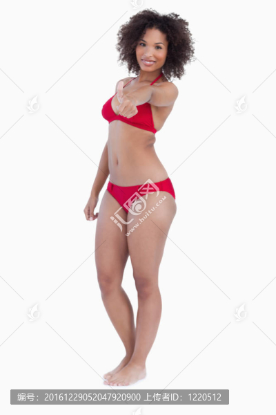 微笑的女人穿著泳衣豎起大拇指